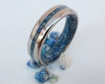 two rings with blue and white stones on the inside, one ring is made out of silver