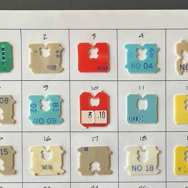 several different colored pieces of paper with numbers and letters in them on a white surface