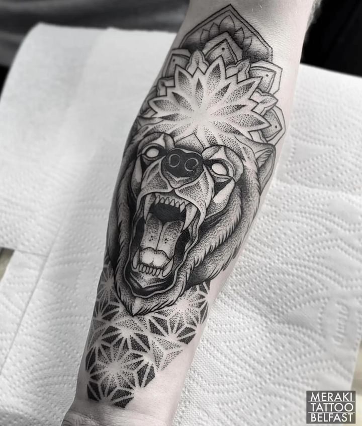 a man's arm with a bear tattoo on it