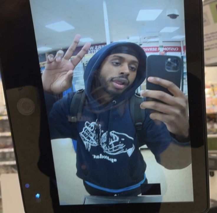 a man is taking a selfie with his cell phone in a store's window