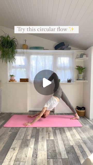 a woman is doing yoga on a pink mat in the middle of a living room