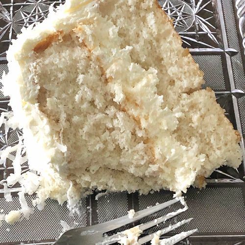 a piece of cake sitting on top of a cooling rack next to a knife and fork