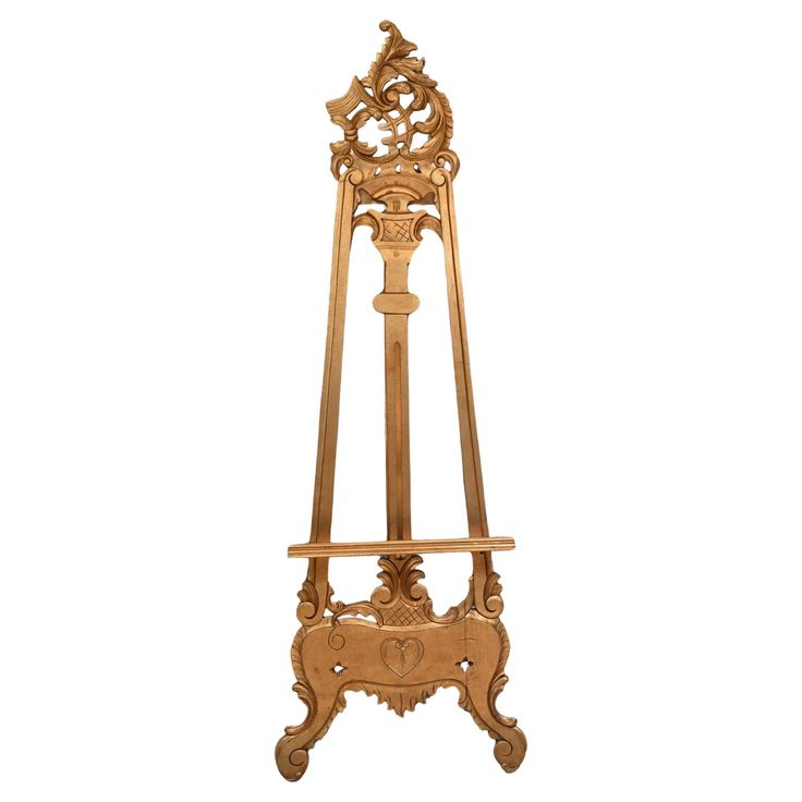 an antique wooden easel with carvings on the top and bottom, sitting against a white background