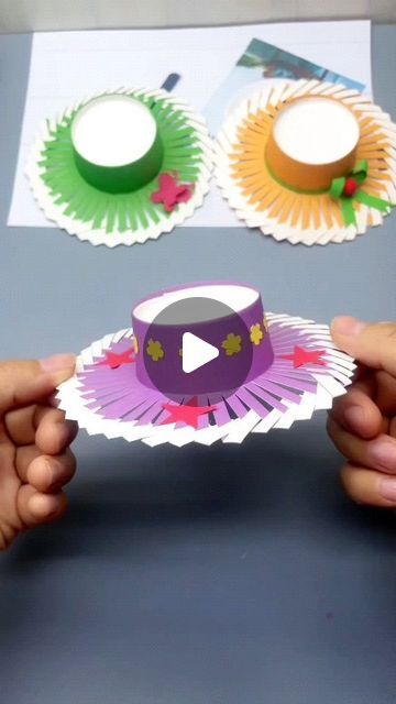 two hands holding paper plates with different designs on them