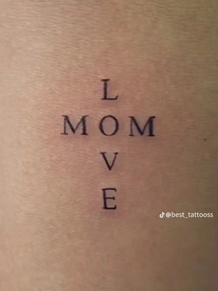 the word i mom love written in cursive font on someone's lower back