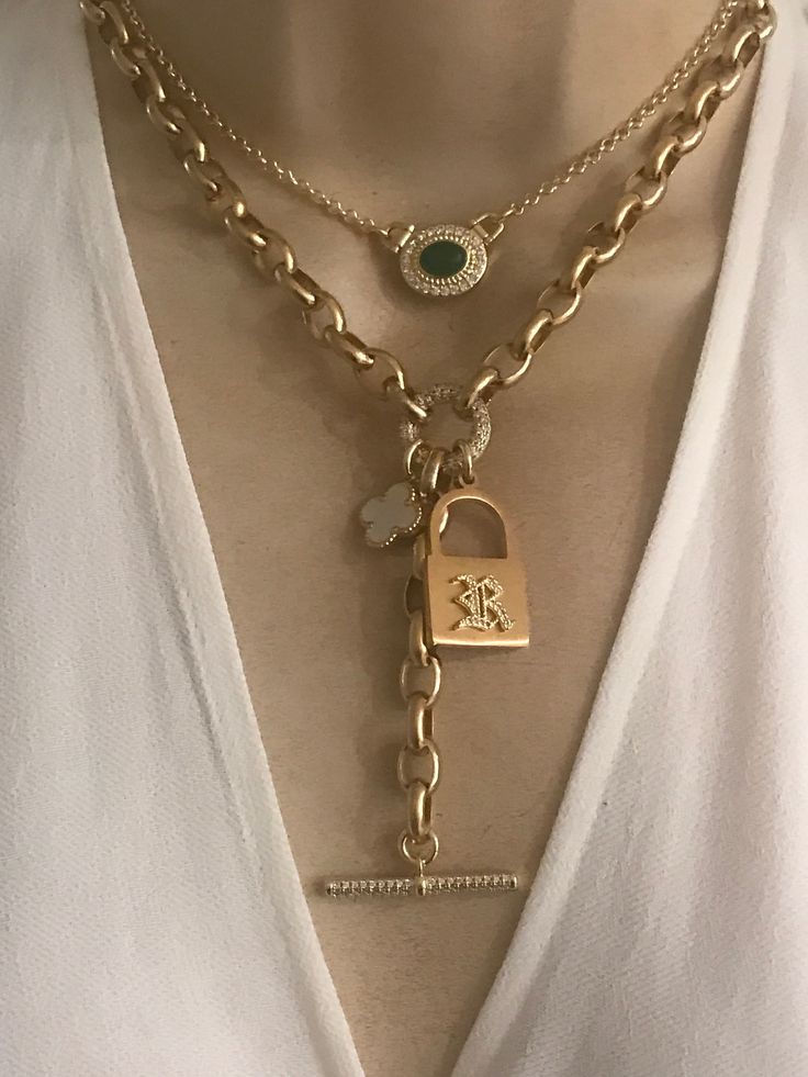 This personalized necklace features a gold plated stainless steel padlock with your choice of one initial in CZ old English font(choose at the checkout). Mother of pearl clover and CZ toggle chain drop add a modern twist to this necklace. Oval link chain is gold plated over stainless steel. Drop toggle length is approximately 3 inches. Necklace length is adjustable 16-18 inches.  🎁All orders are shipped in a box. Gift messages are attached to the box. Elegant Personalized Chain Link Necklace, Elegant Personalized Chain Link Necklaces, Elegant Personalized Metal Chain Necklace, Chic Toggle Necklace As A Gift, Chic Yellow Gold Toggle Necklace Gift, Chic Metal Charm Jewelry, Chic Metal Jewelry With Charms, Elegant Metal Charm Necklaces, Elegant Metal Charm Necklace