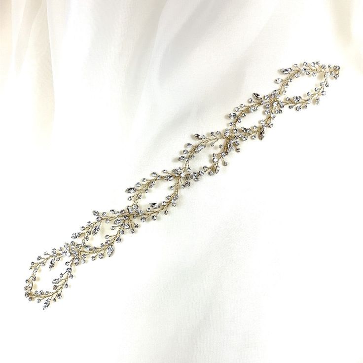 This delicate bridal hair vine is finished with a glamorous luster and fine detailing. Its shimmering structure intertwined with illuminating crystals is sure to make this piece a head turner as it glows and frames your gorgeous wedding look. Use it in the front or back of an updo, around a bun, and many other ways. Available in all crystal or crystal and pearl, and comes in silver or gold. -Genuine crystals -Approximately 1.5in at the widest point x 14in long (3.8cm x 35.6cm) -Rhodium or gold p Gold Crystal Embellished Headpieces For Wedding, Adjustable Crystal Embellished Hair Accessories For Weddings, Adjustable Crystal Embellished Headpieces For Wedding, Elegant Adjustable Bridal Accessories, Elegant Adjustable Hair Accessories For Ceremony, Elegant Adjustable Jewelry For Ceremonies, Elegant Crystal Embellished Crown Headpiece, Elegant Crown-shaped Hair Accessories With Matching Headband, Elegant Crown Shaped Hair Accessories With Matching Headband