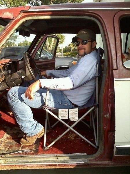 a man sitting in the driver's seat of a truck with his feet up