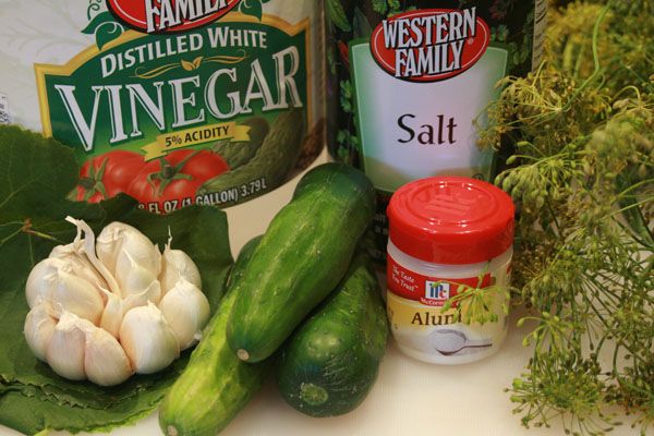 some vegetables are sitting on a table next to bottles of wine and seasoning fluid