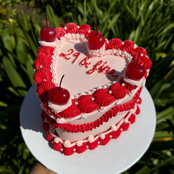 a heart shaped cake with cherries on top