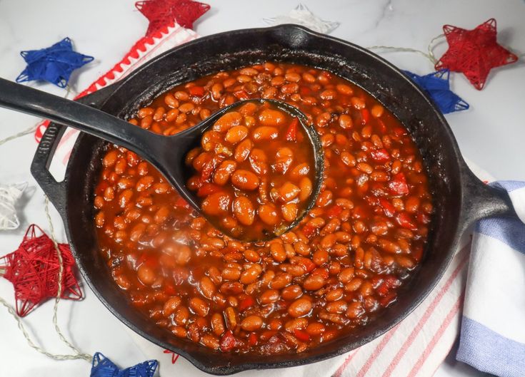 a large pot filled with beans on top of a red white and blue table cloth