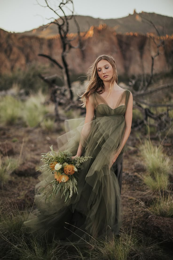 a woman in a green dress holding a bouquet