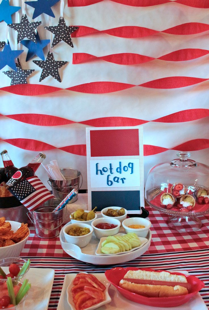 an american flag themed party with hot dogs and other foods on the table for eating