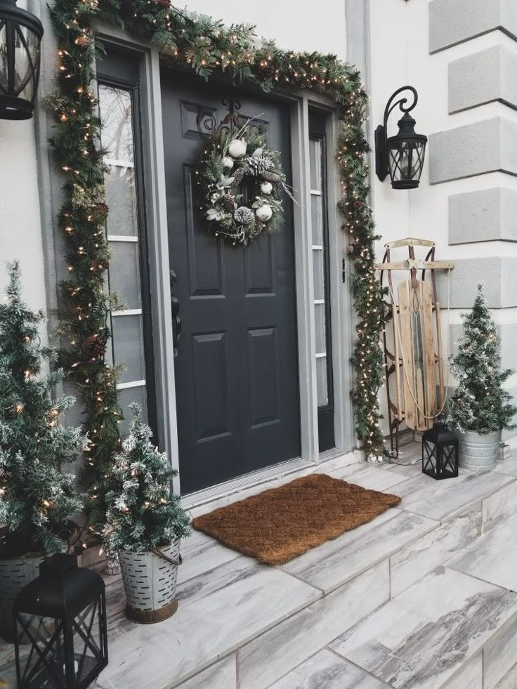 a front door decorated for christmas with wreaths and lights