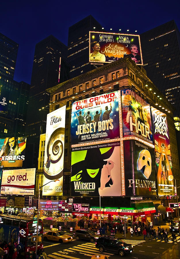 the times square in new york city is lit up at night with many billboards