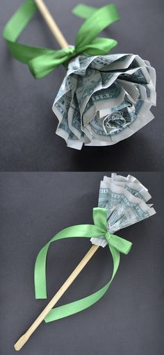 dollar bills tied to a wooden stick with green ribbon and bow on it, sitting on a black surface