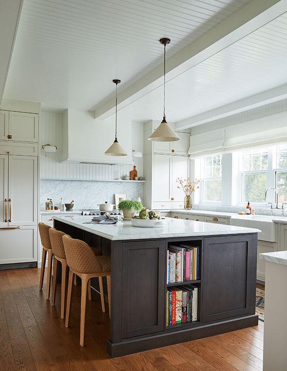 a large kitchen with an island in the middle and lots of bookshelves on it