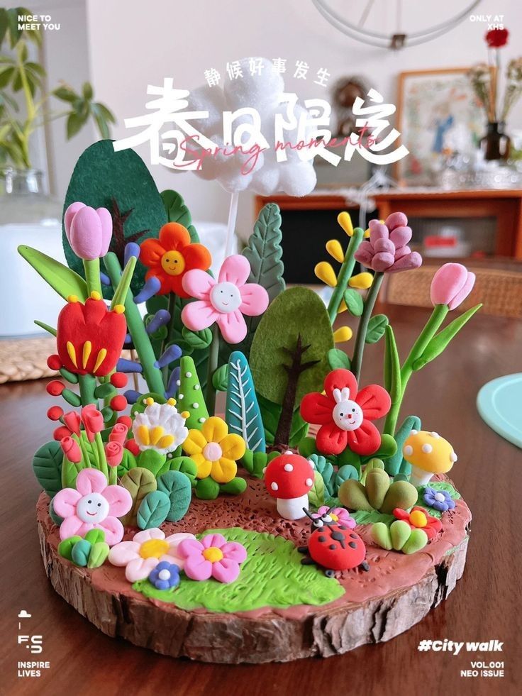 the cake is decorated with colorful flowers and plants on it's base, along with a ladybug figurine