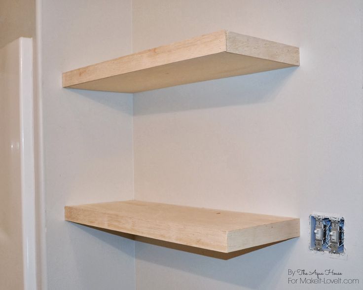 two wooden shelves on the wall in a bathroom