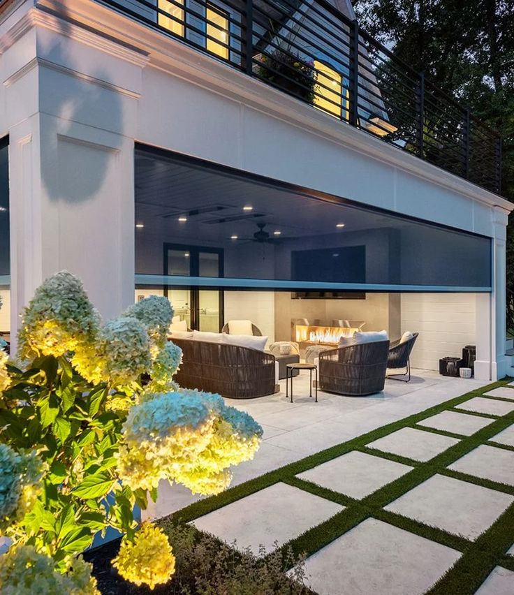 an outdoor living room and dining area are lit up at night