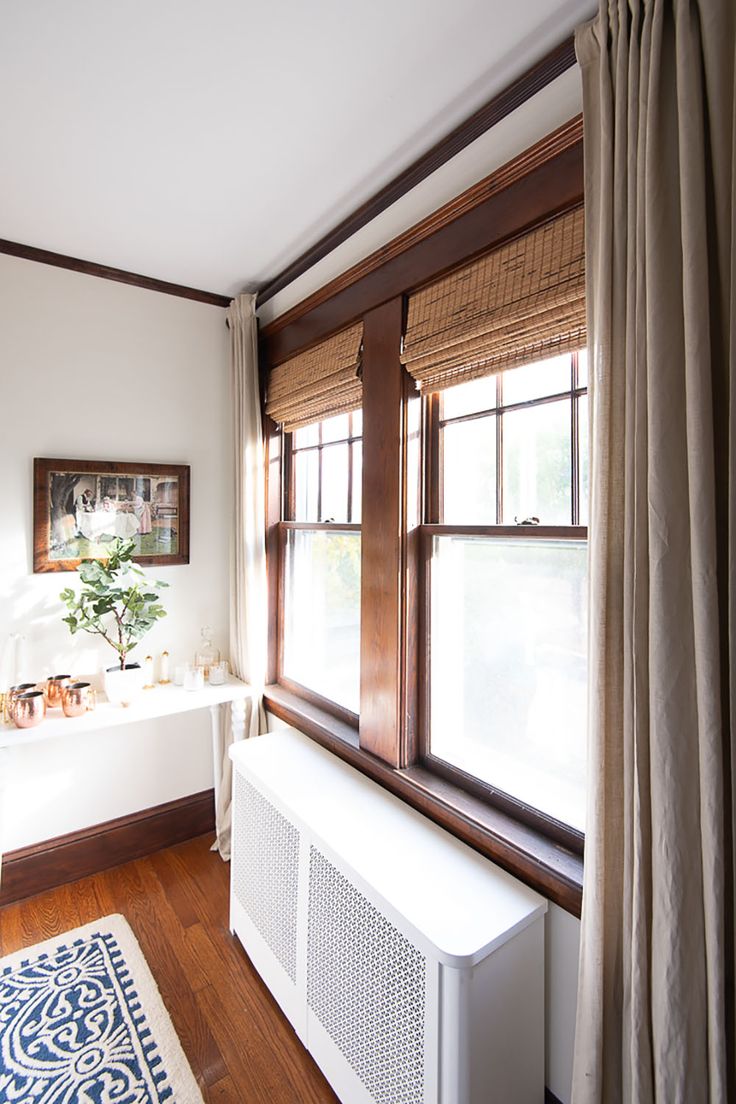 an air conditioner sitting next to a window in a room with wood floors and white walls