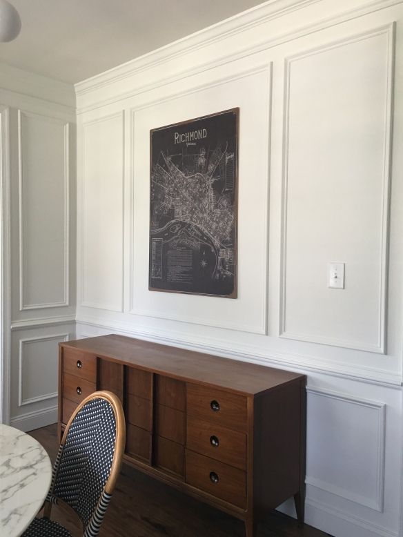 a dining room table and chairs in front of a chalkboard on the wall above it