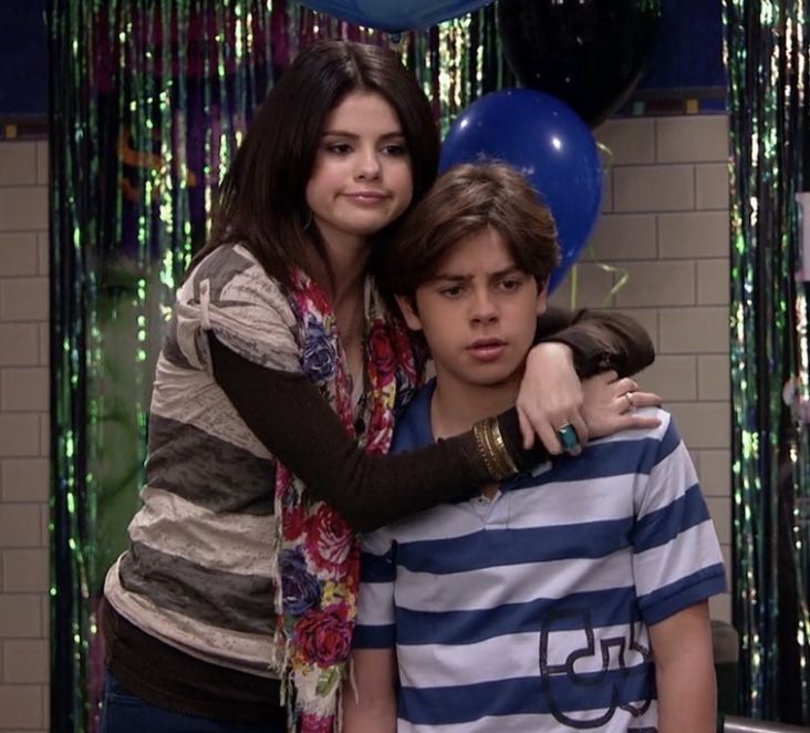 two young people hugging each other in front of balloons and confetti streamers