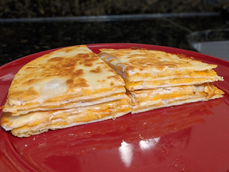 two quesadillas stacked on top of each other on a red plate,