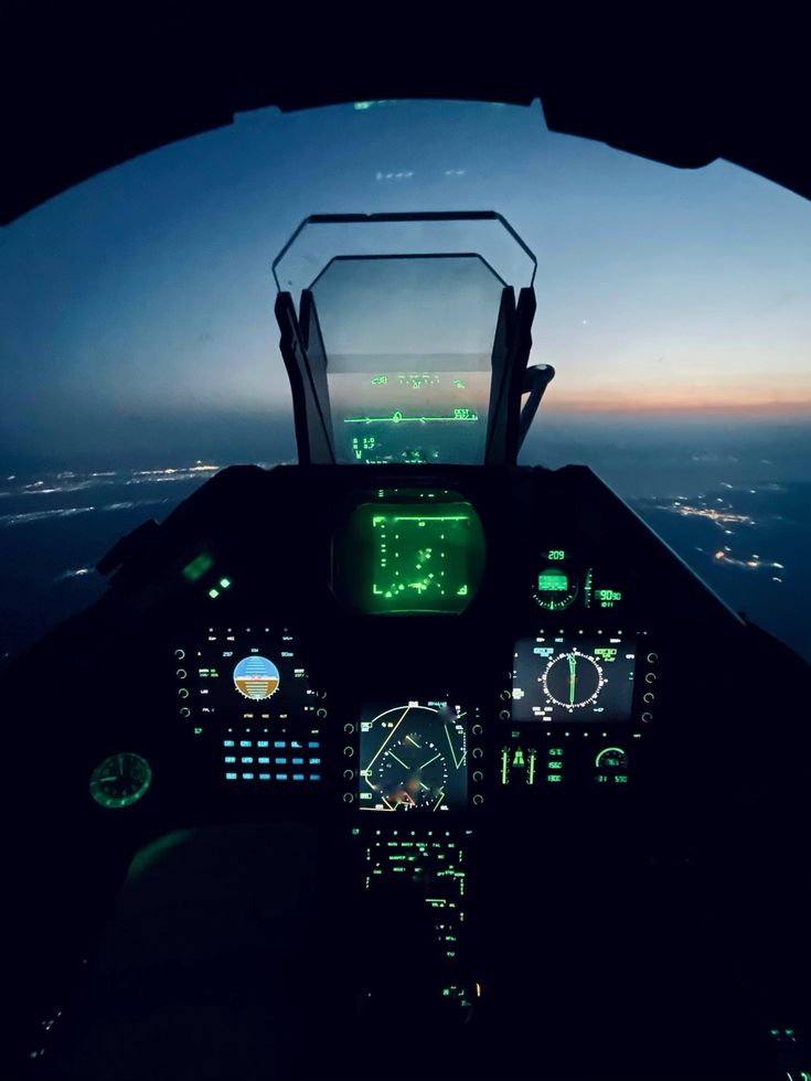 an airplane cockpit with the lights on and illuminated in green as it flies through the air