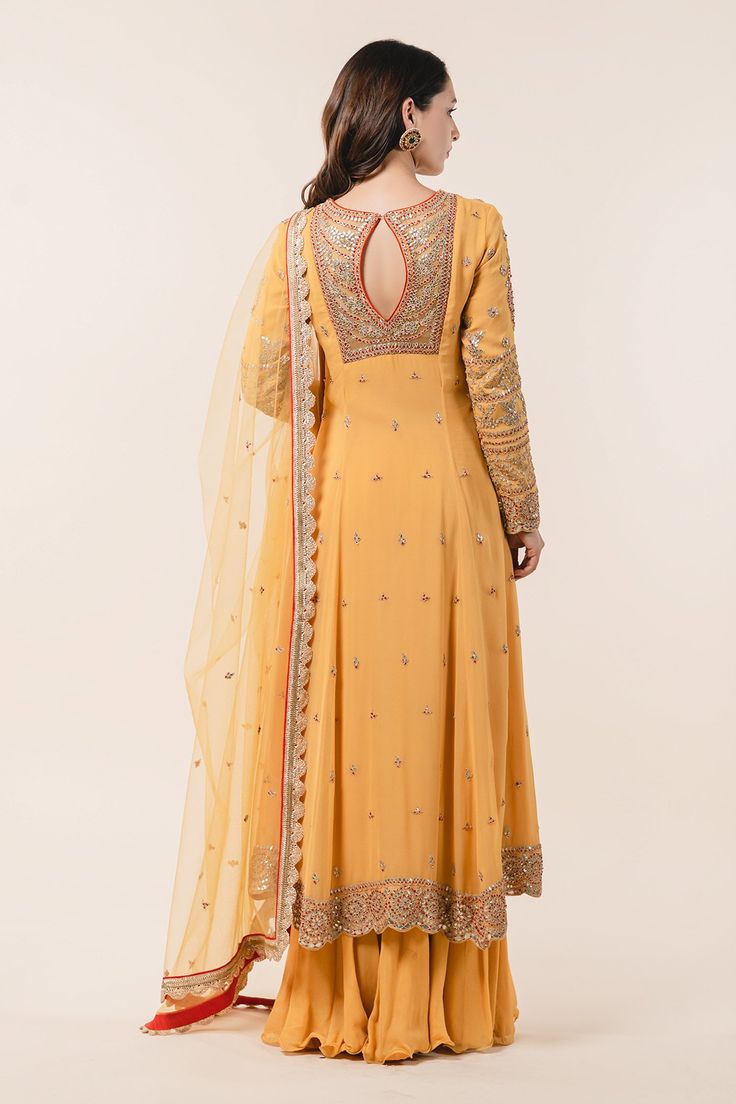 Mustard kalidar kurta highlighted with intricate gota embroidery, potli placket and scallop edged hem. Comes with sharara and tulle dupatta.
Component: 3
Embroidered
Neckline: Round
Sleeve Length: Full
Fabric: Kurta and Sharara: Georgette; Dupatta: Tulle 
Color: Yellow
Resham French knot, gota embroidery and embellishments 
Kalidar kurta 
Keyhole at the back with hook closure
High low hem
Embroidered dupatta with scallop edge - Aza Fashions Kurta And Sharara, Gota Embroidery, Mustard Fabric, Yellow Kurta, Blouse Yoke, Tulle Embroidery, Georgette Dupatta, Embroidered Dupatta, French Knots