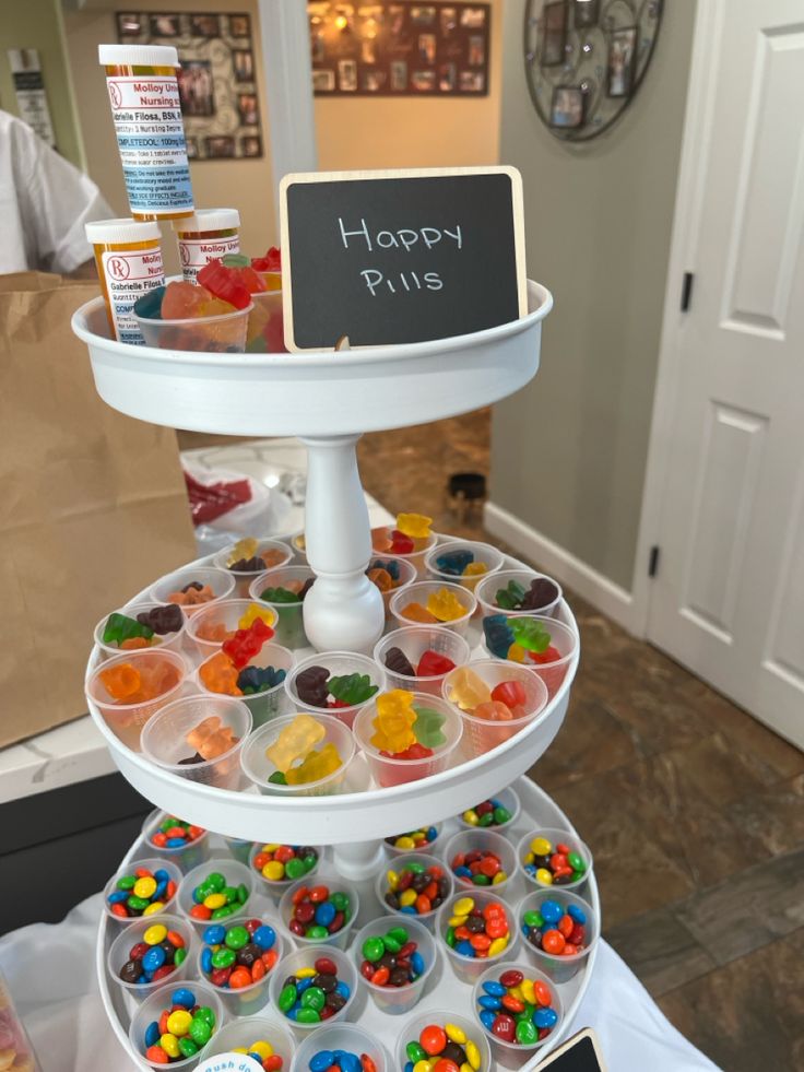 a three tiered tray filled with lots of candies on top of a table