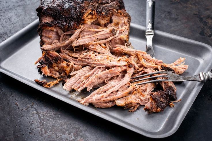 a roast beef on a plate with fork and knife