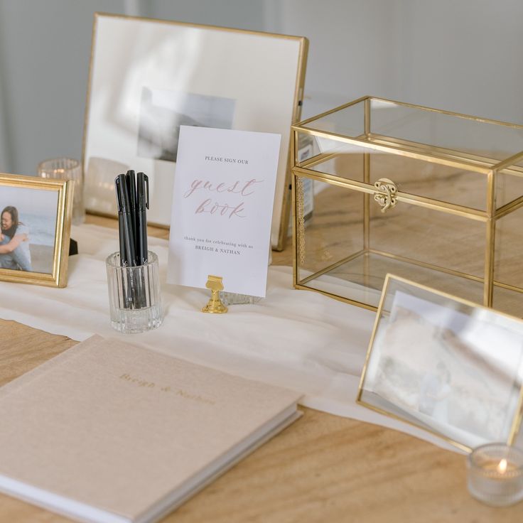 the table is set up with photos, pens and other things to write on it