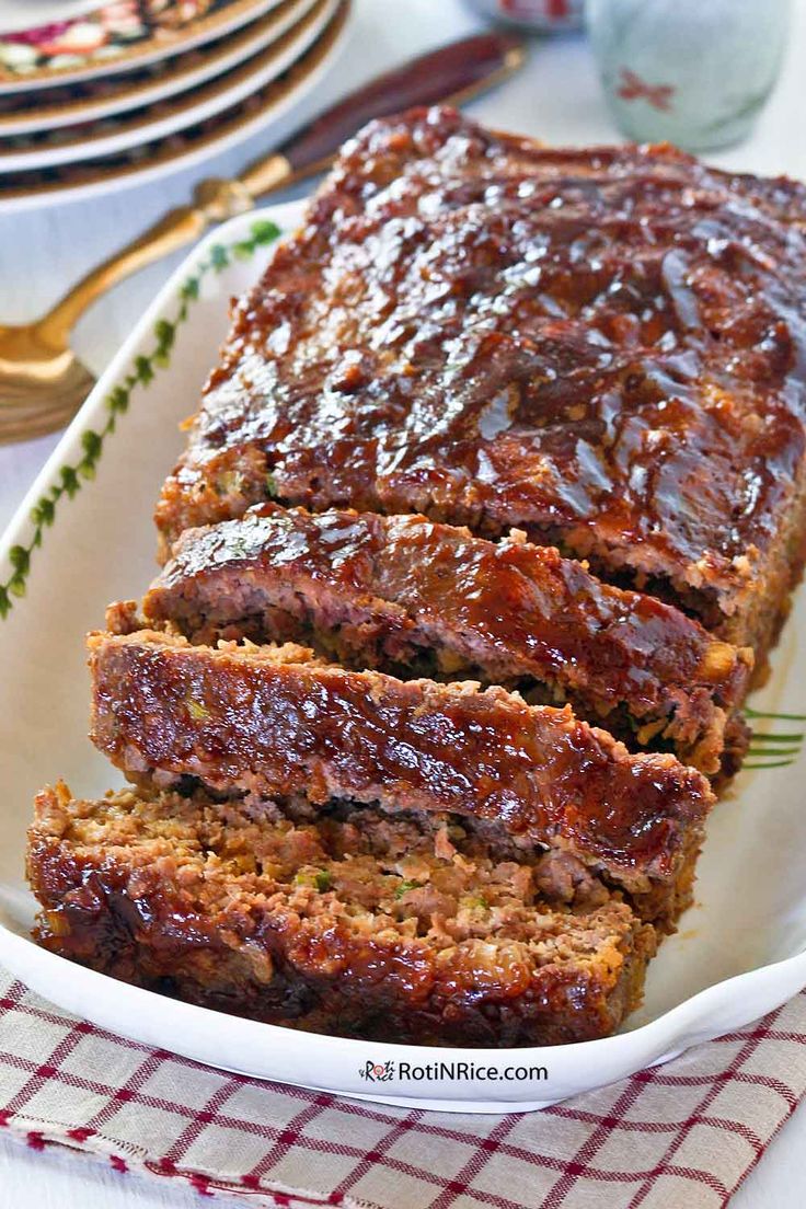 sliced meatloaf in a white dish on a red and white checkered napkin