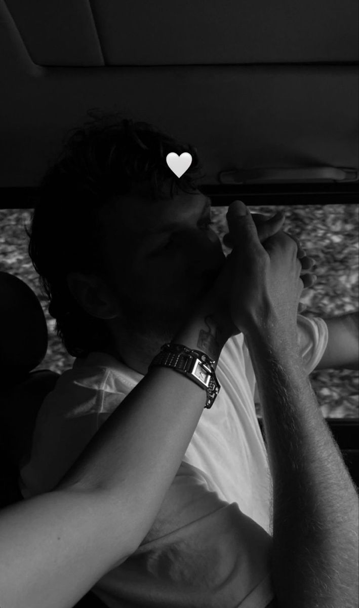 a man sitting in the back seat of a car with a heart on his forehead