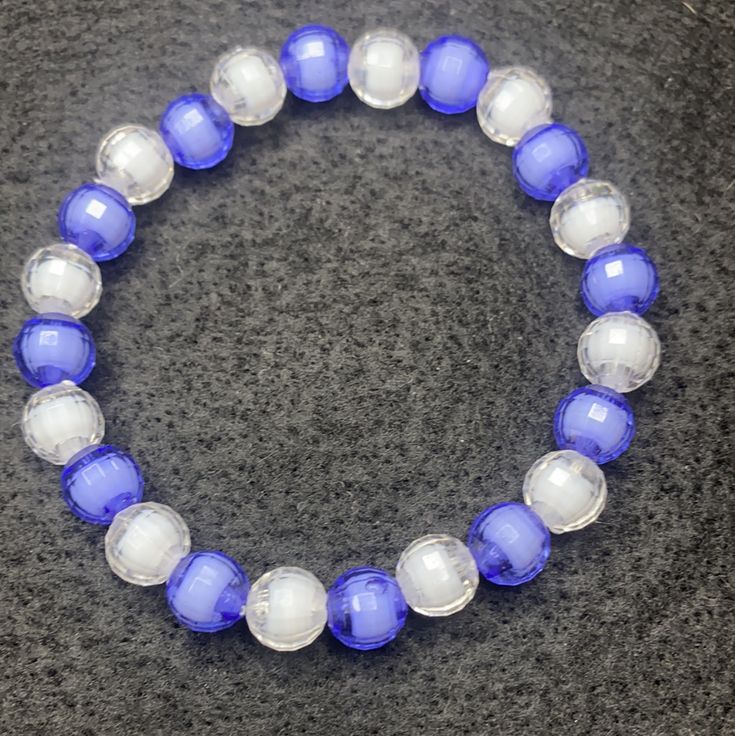 Material: Clear string Color: Purple and white pearls Type: Bracelet Style: Casual Cheap White Braided Bracelet With Colorful Beads, Elegant Blue Stretch Bracelet With Faceted Beads, Elegant Blue Adjustable Pearl Bracelet, Handmade Elegant Blue Pearl Bracelet, Elegant Adjustable Blue Pearl Bracelet, Elegant Adjustable Blue Beaded Bracelets, Elegant Handmade Blue Pearl Bracelet, Blue Hand-strung Pearl Bracelet With Round Beads, Elegant Blue Hand-strung Crystal Bracelet