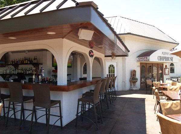 an outdoor bar with lots of chairs around it