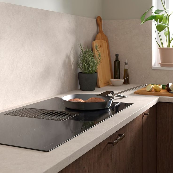 a kitchen counter with a stove top and cutting board next to it on the counter