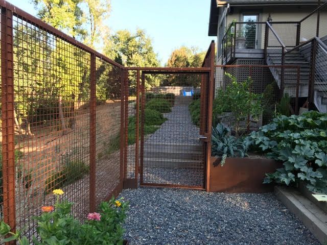 an iron gate is open on the side of a house