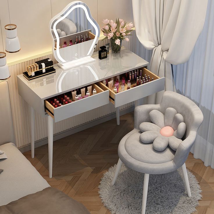 a dressing table with a mirror, stool and makeup on it in a small room