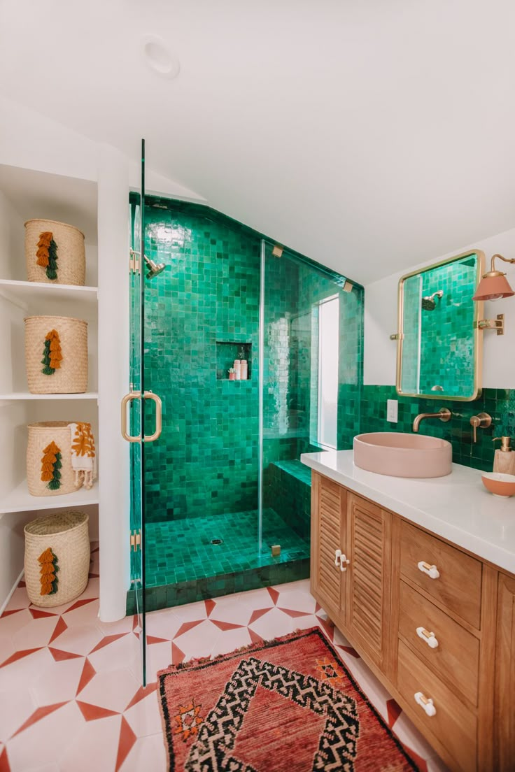 a bathroom with green tiles and wooden cabinets, including a shower stall in the corner