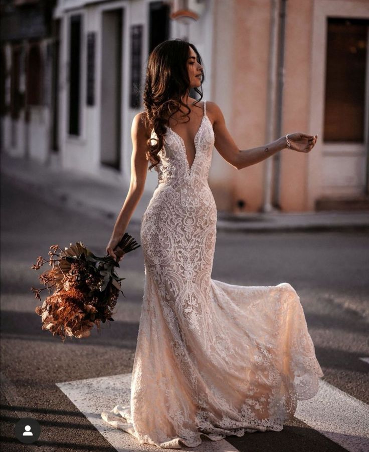 a woman in a wedding dress is crossing the street with her hand on her hip