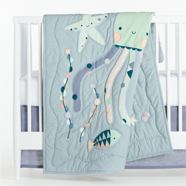 a crib bed with an ocean themed blanket