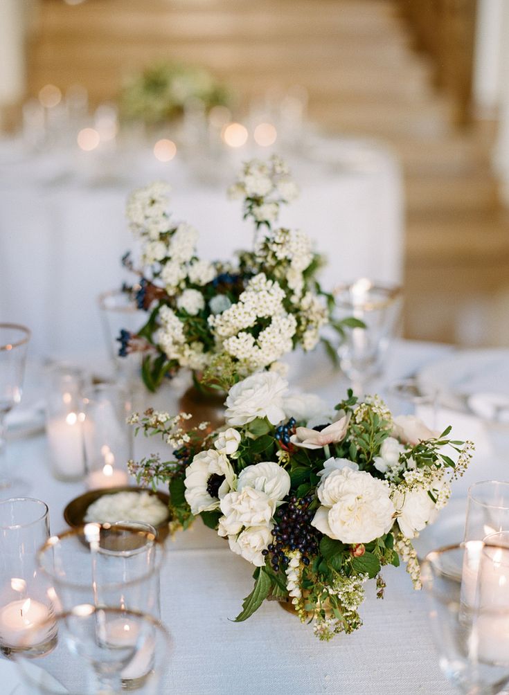 the table is set with white flowers and candles