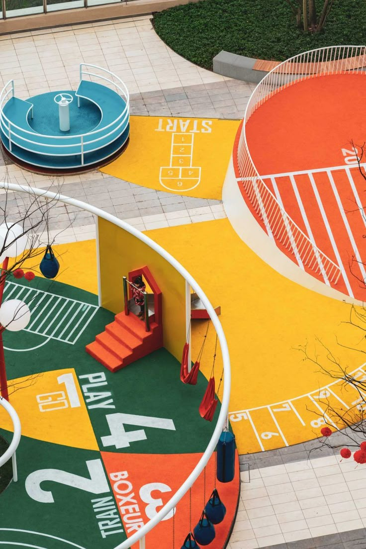 an aerial view of a playground with swings, slides and basketball hoops on the ground