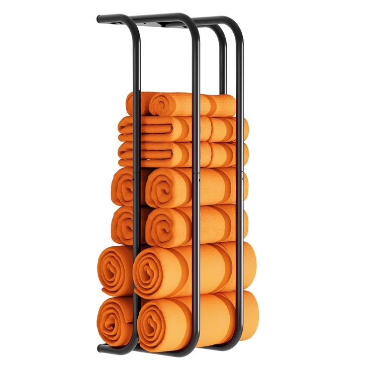 a stack of orange towels sitting on top of a black metal rack next to a white wall