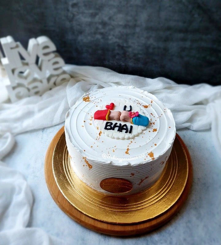 a white cake with the word bha on it sitting on top of a gold plate