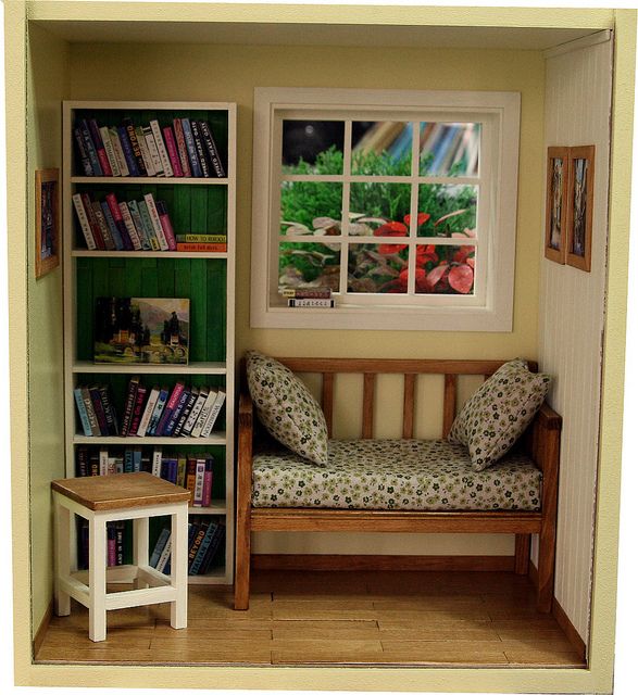 a doll house room with a bench and bookshelf