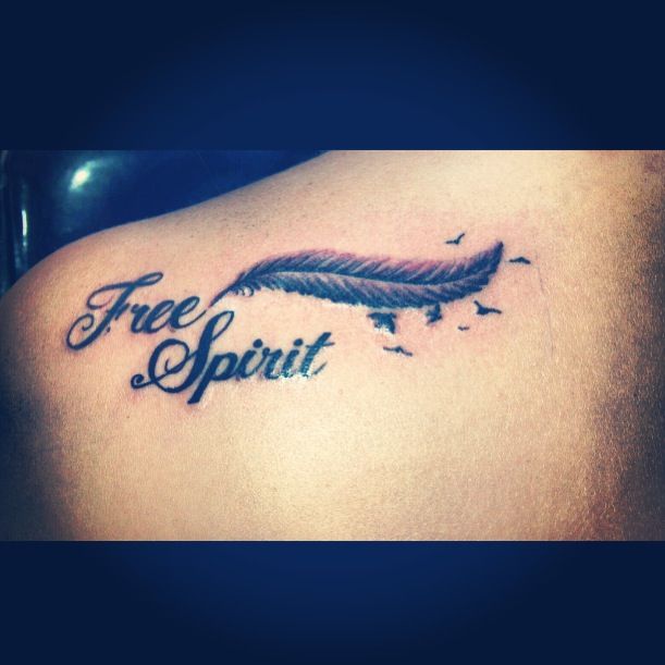 a tattoo that says free spirit with a feather