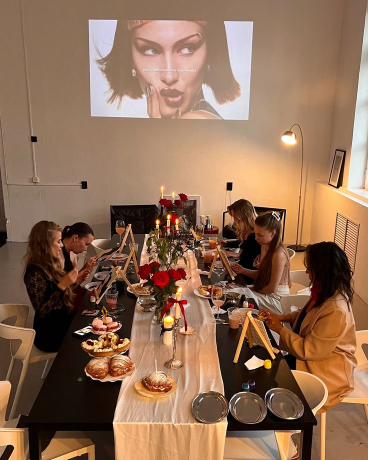 a group of people sitting around a table with food